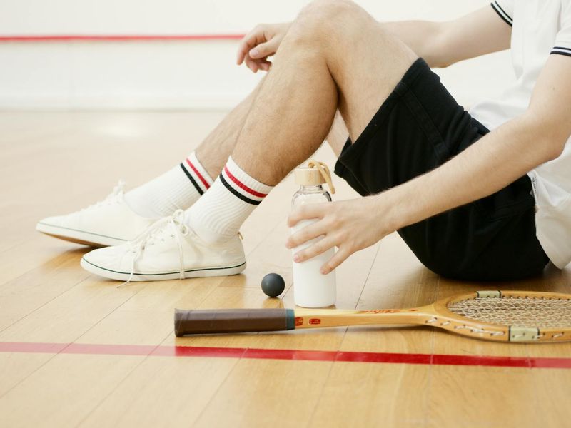 Athletic footwear and water bottle on a clean floor.